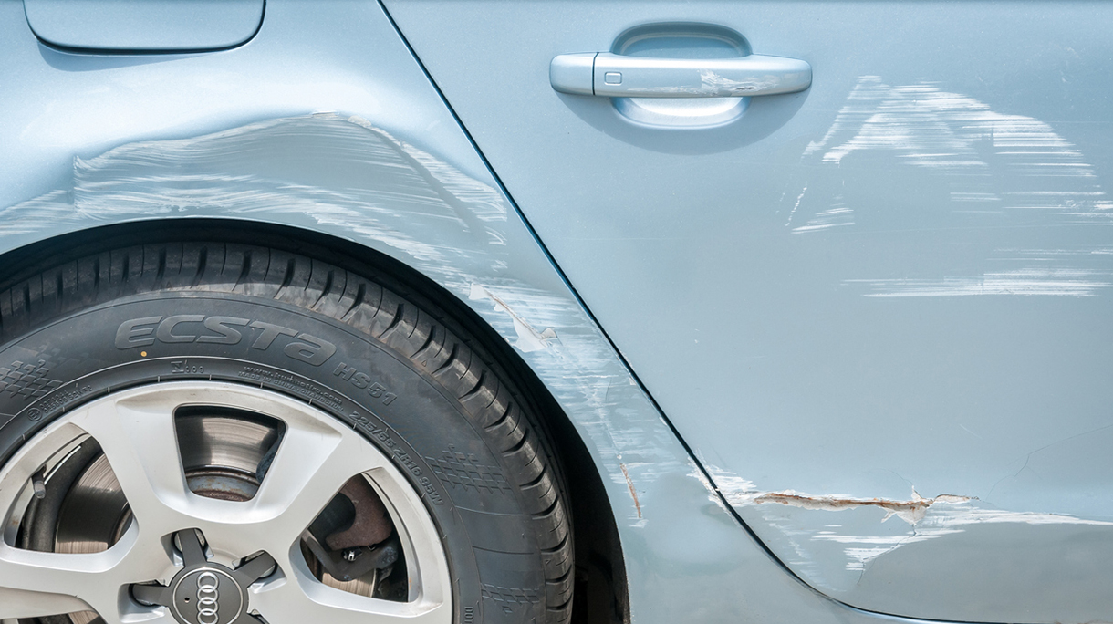 New silver Audi car with scratched and damaged paint near wheel and doors after crash accident and collision.