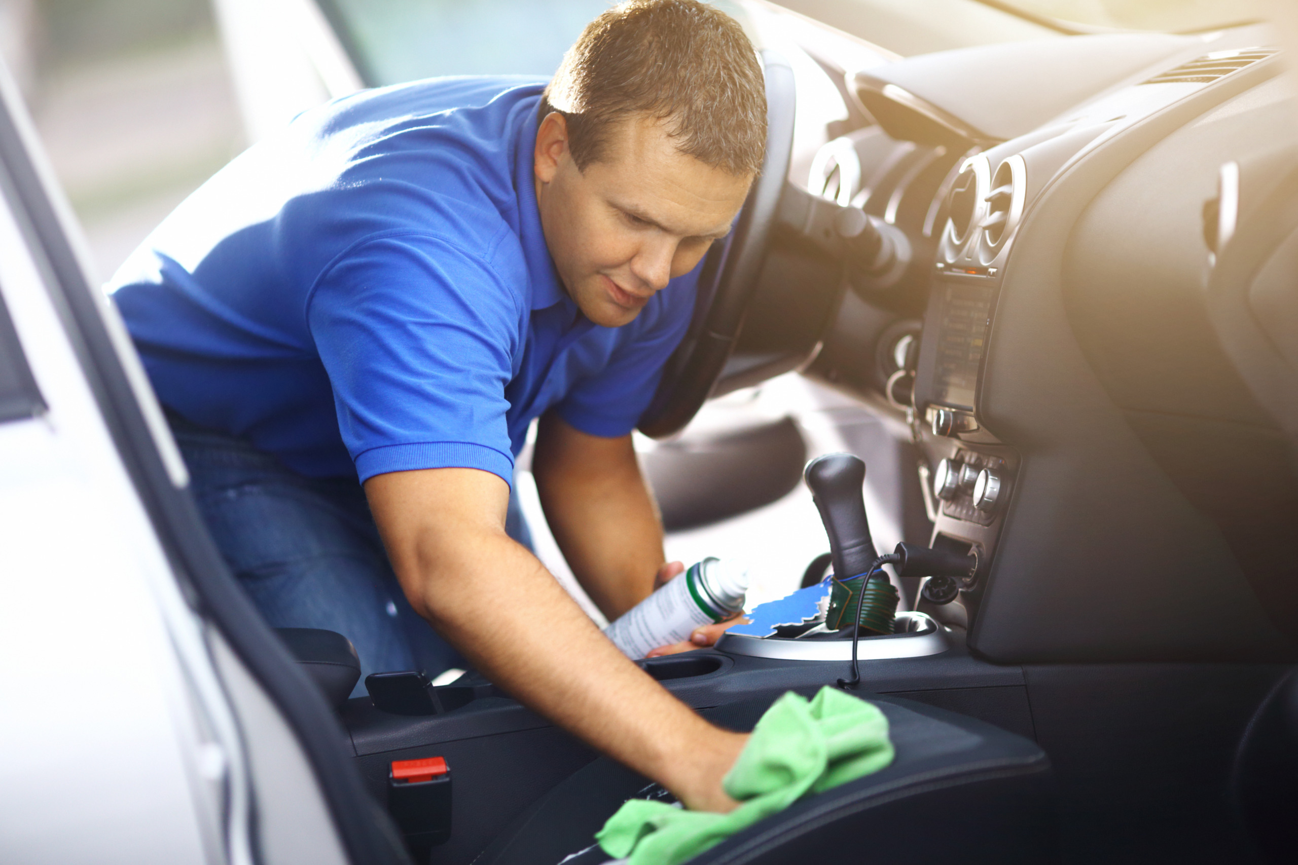 Man cleaning upholstery of his vehicle.