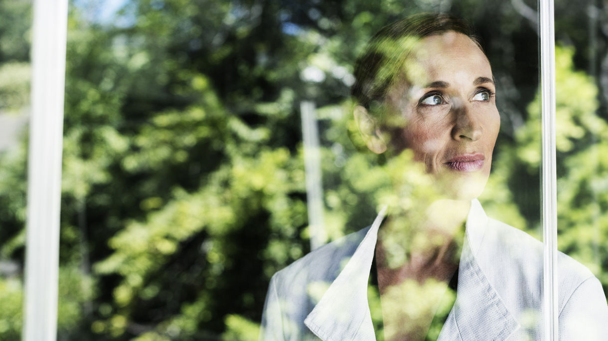 Thoughtful businesswoman by glass window