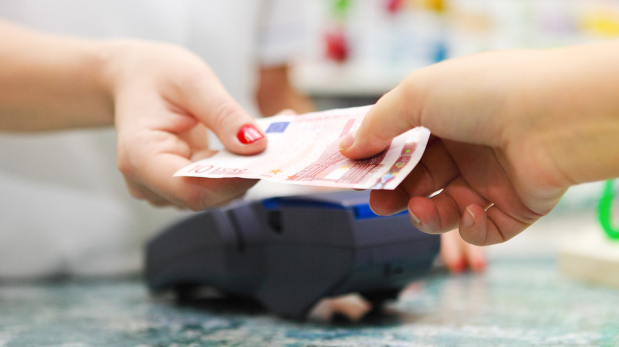 Paying for medicine using cash at pharmacy