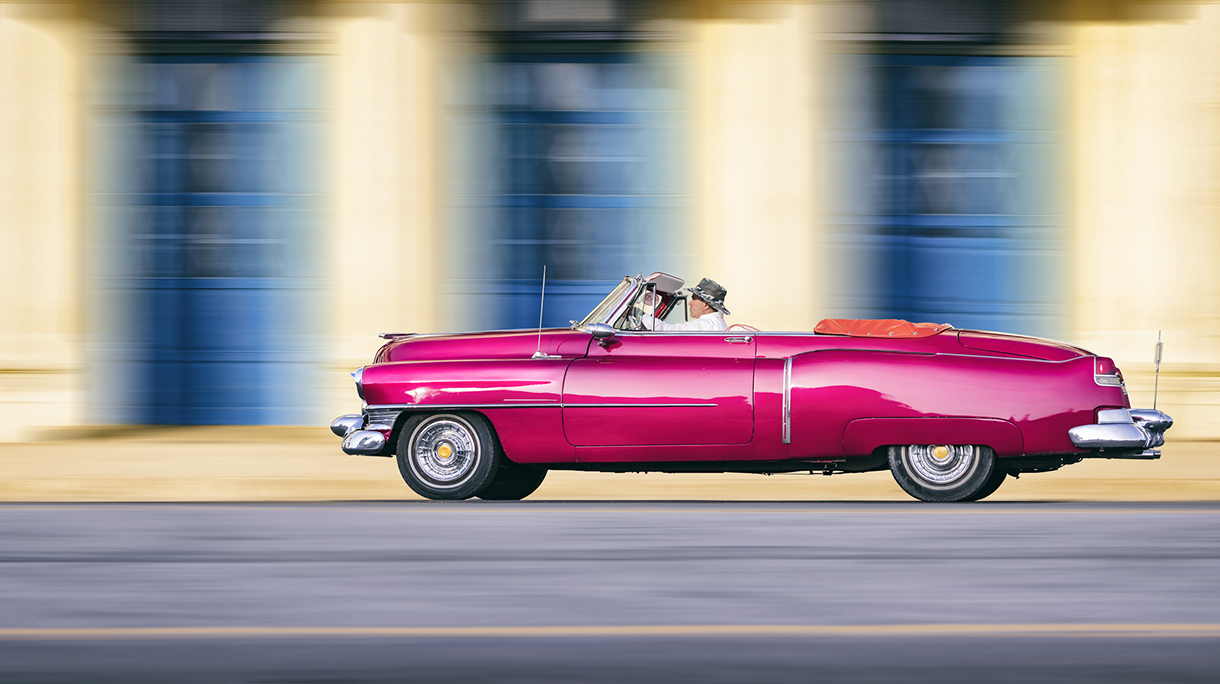 Vintage pink oldtimer car driving through Old Havana Cuba