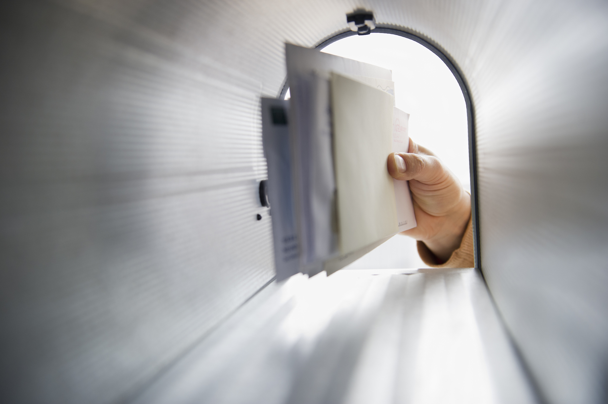Close-up of man’s hand removing letters from letter box
