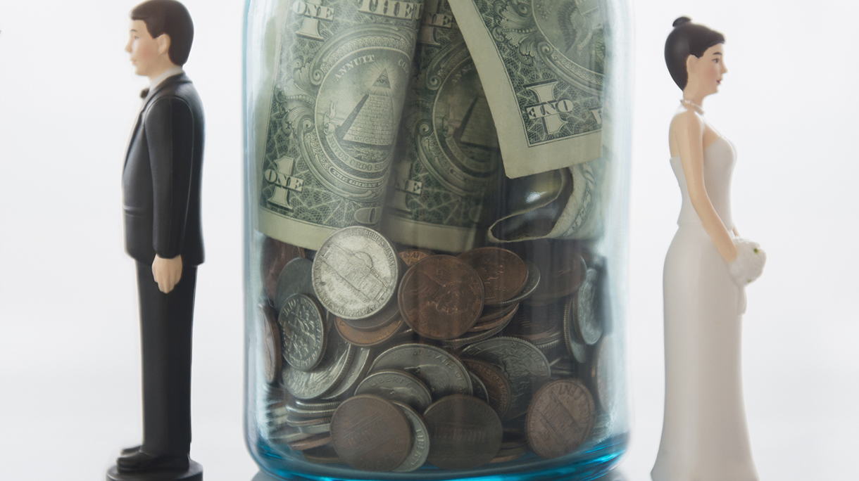 Close up of bride and groom dolls near savings jar