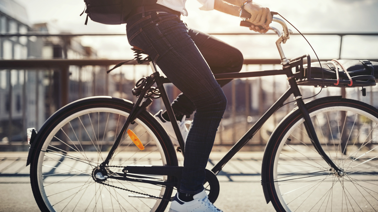 Low section of businessman riding bicycle on bridge
