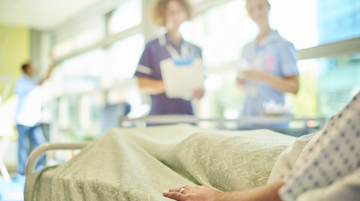 senior nurse chatting to student nurse and patient