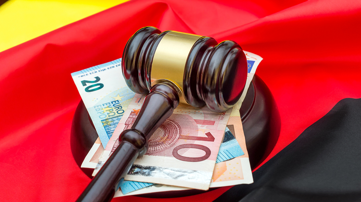 Gavel with euro bills on German flag.