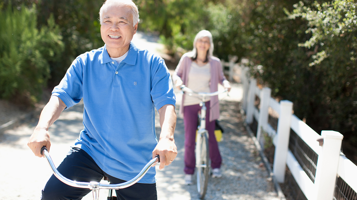 Smiling older couple riding bicycles