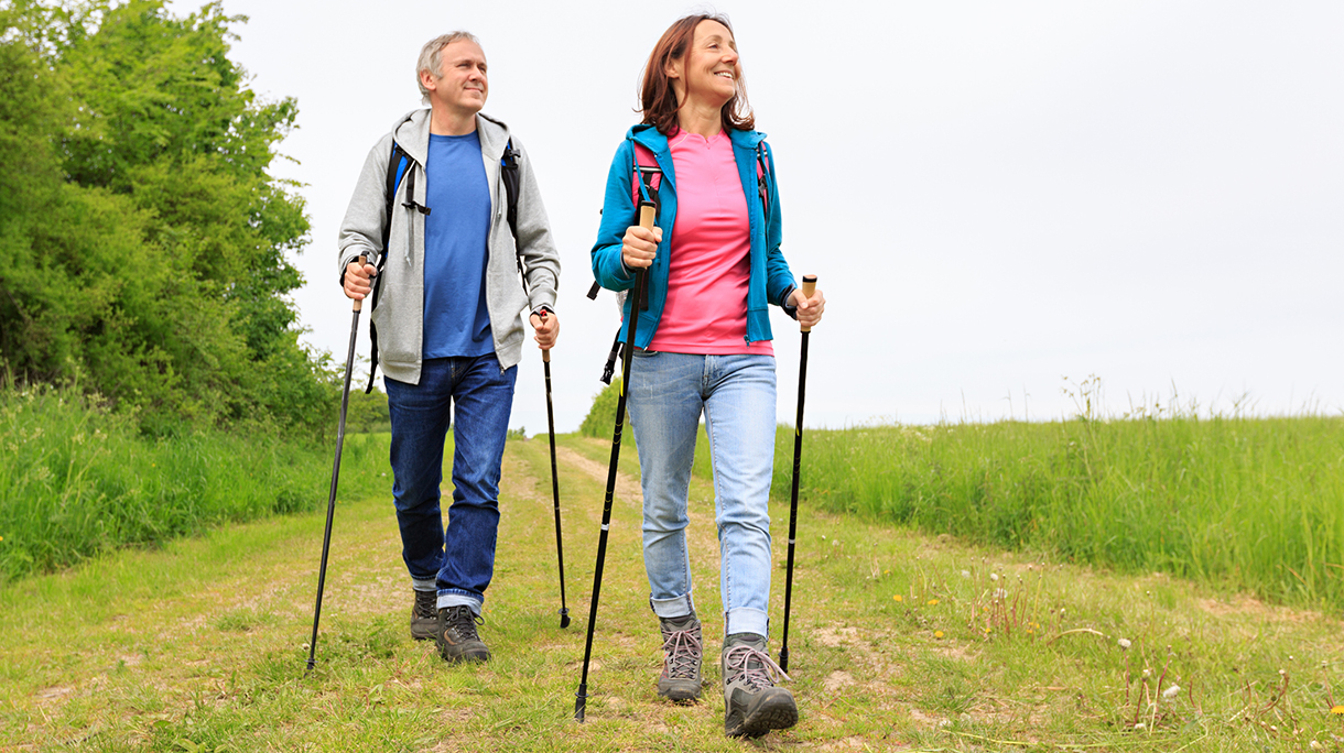 Nordic walking – active mature couple enjoying hiking