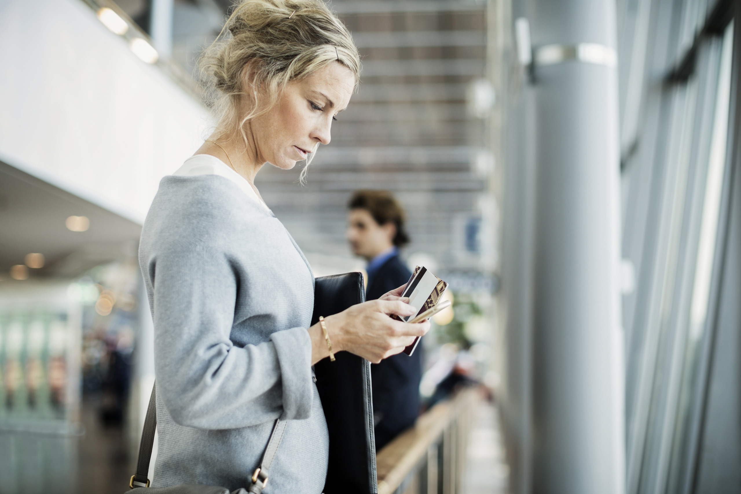 Side view of businesswoman using smart phone at airport