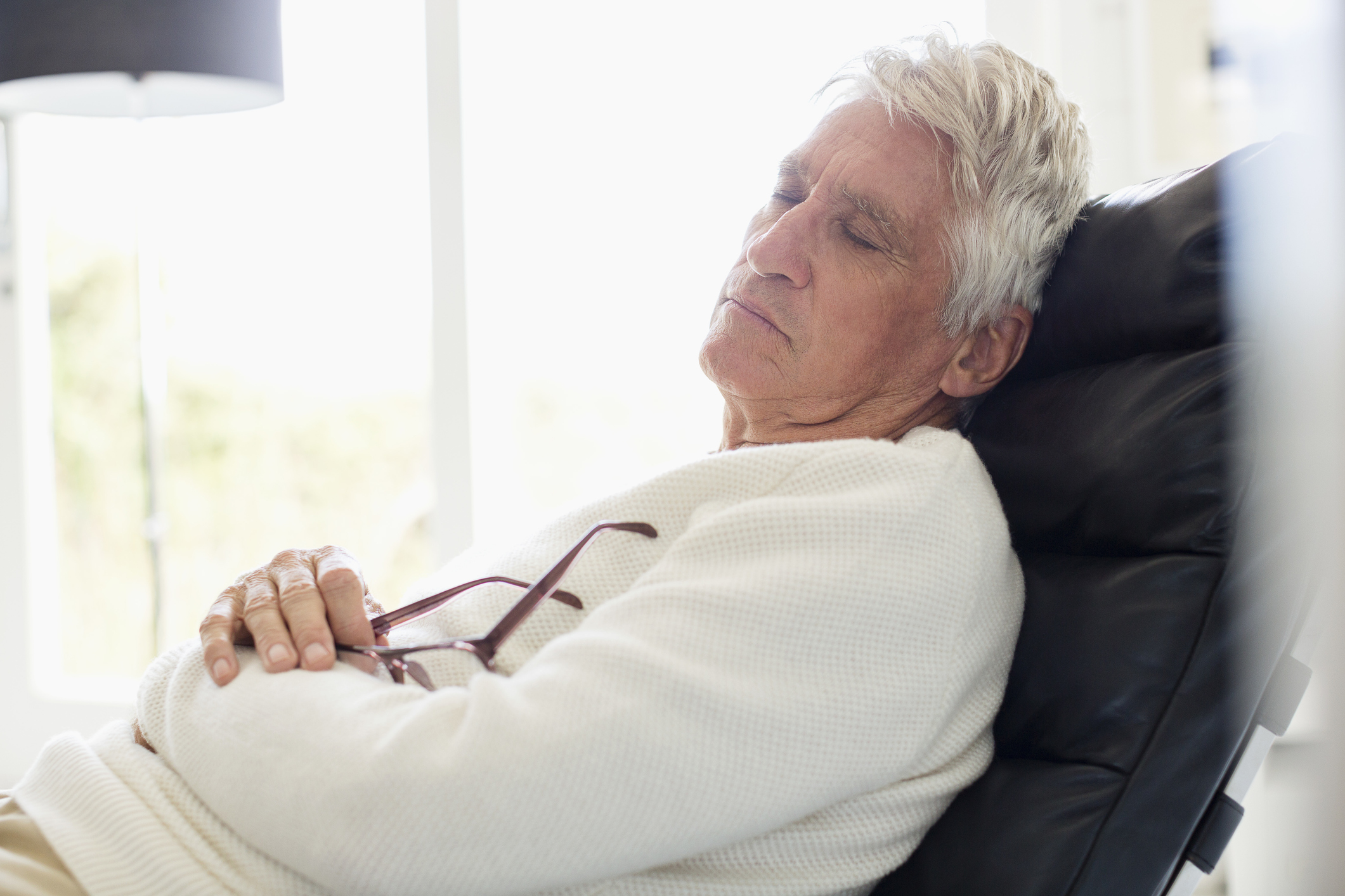 Senior man sleeping on chair