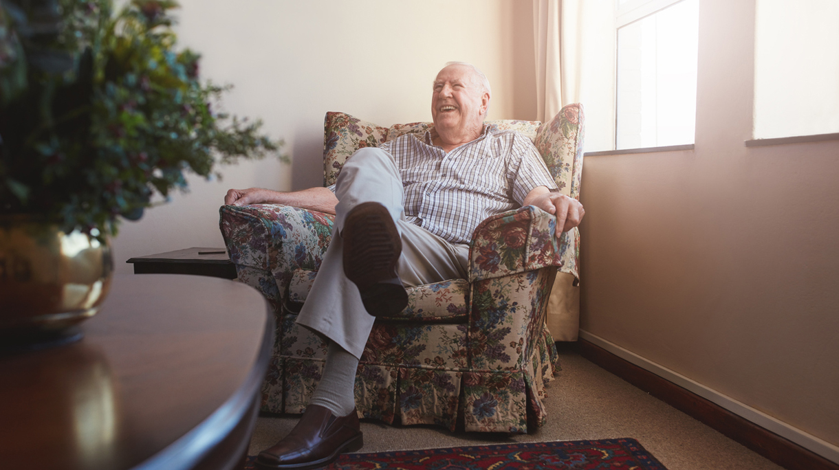 Elderly man sitting on arm chair at old age home