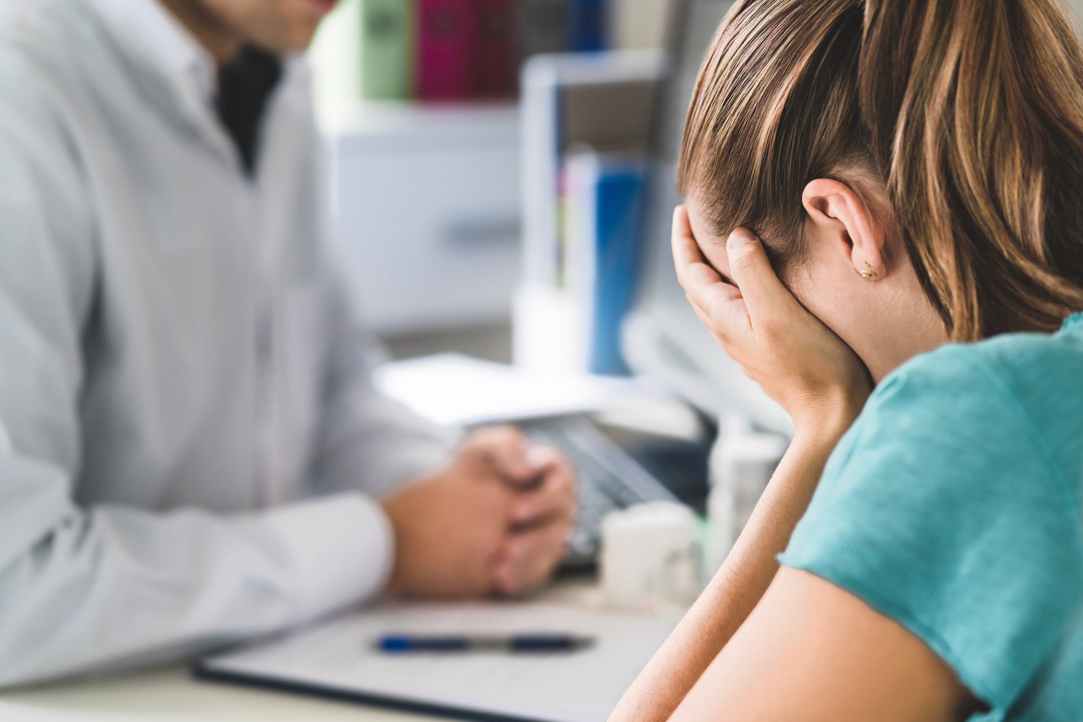 Sad patient visiting doctor. Young woman with stress or burnout getting help from medical professional or therapist. Anxiety, depression or mental health problems concept.