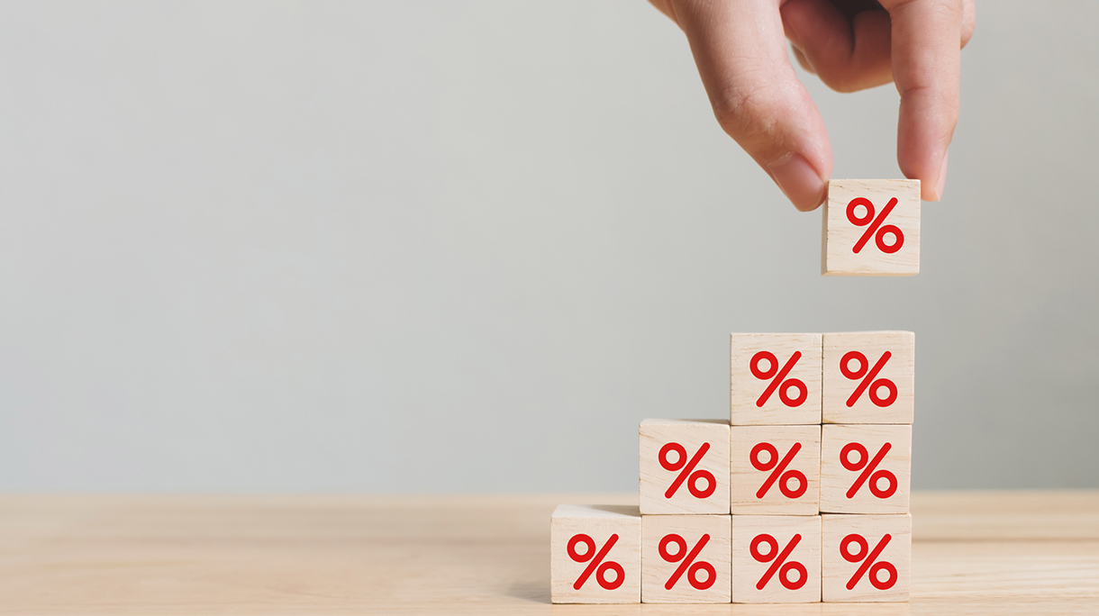 Interest rate financial and mortgage rates concept. Hand putting wood cube block increasing on top with icon percentage symbol upward direction