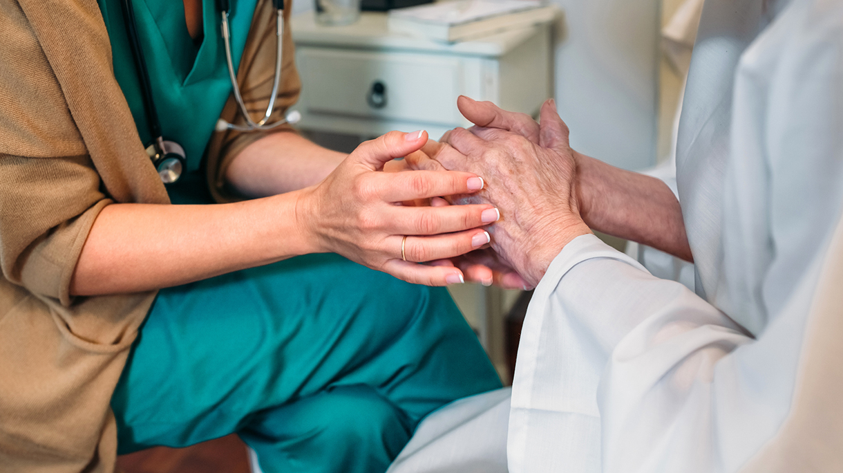 Nurse Consoling Senior Patient In Hospital
