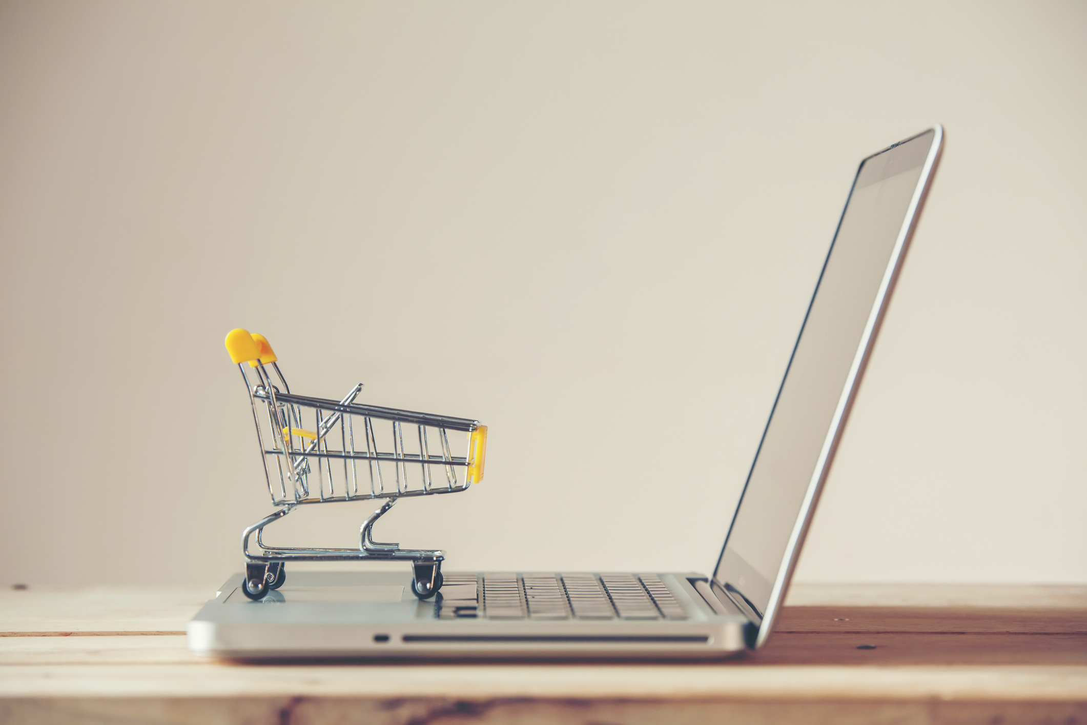 Small Shopping Cart On Laptop With Copyspace : Online Shopping Concept. E-commerce.