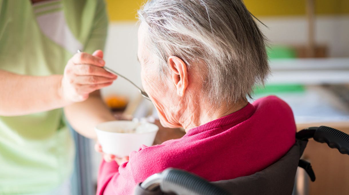 Taking care of elderly sick woman in wheelchair