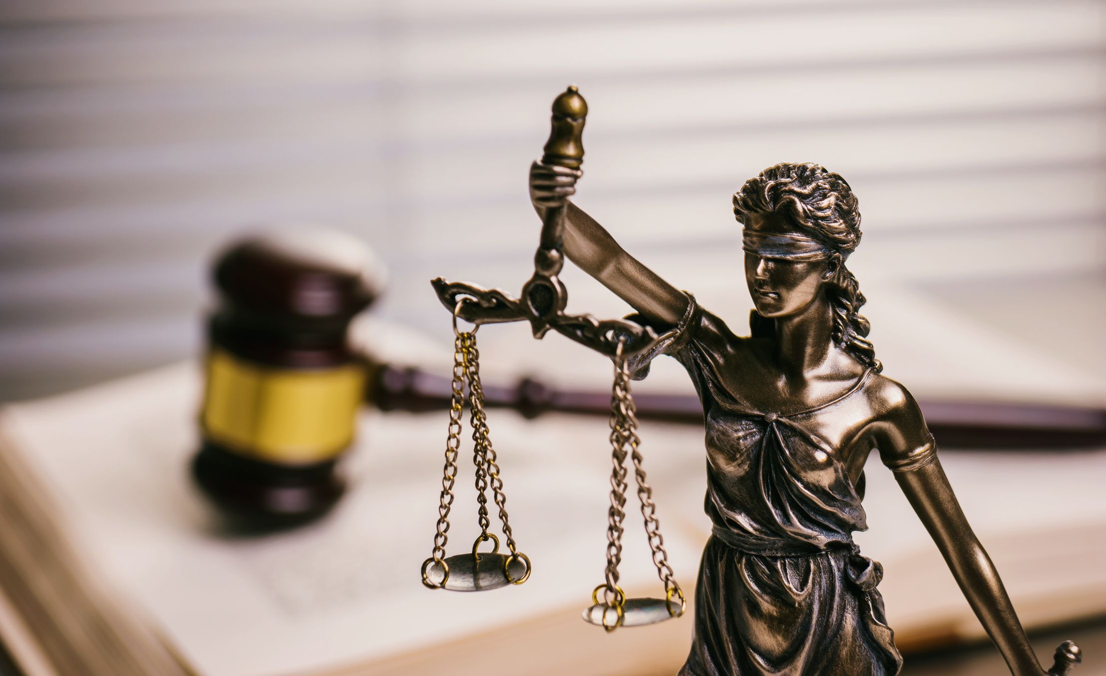 Close Up Of Lady Justice Against Gavel On Book