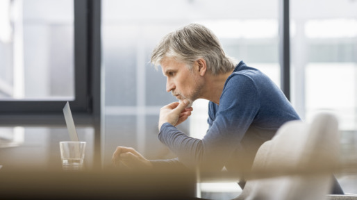 Mature businessman working in office, using laptop