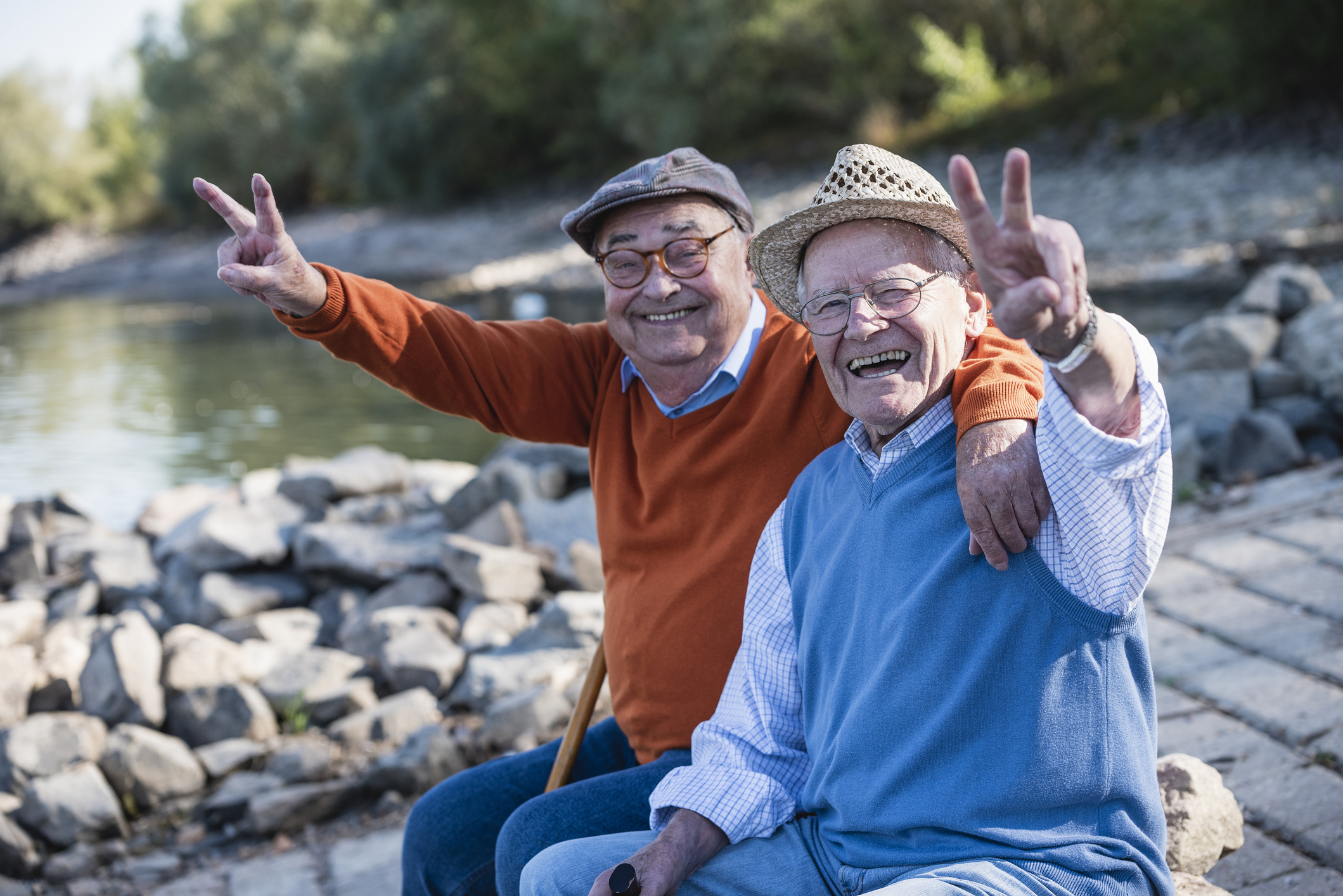 Two old friends sitting by the riverside, having fun