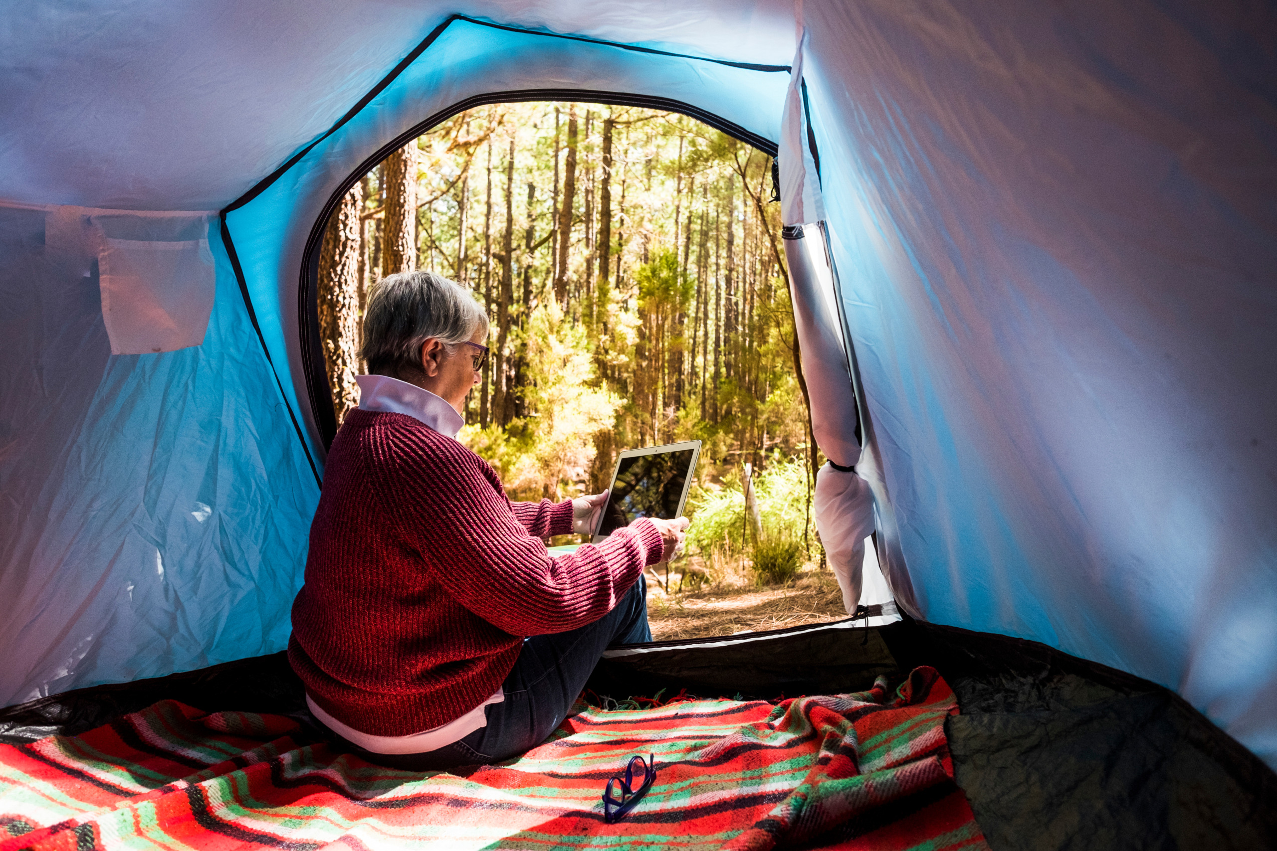 Woman Photographing Trees While Sitting In Tent