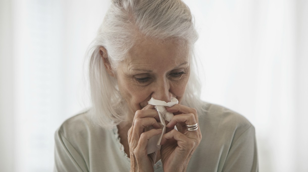 Senior Caucasian woman blowing her nose