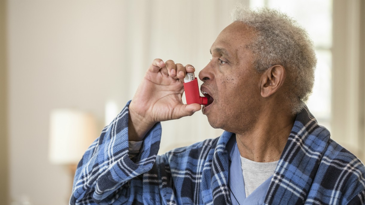 Senior African American man using inhaler