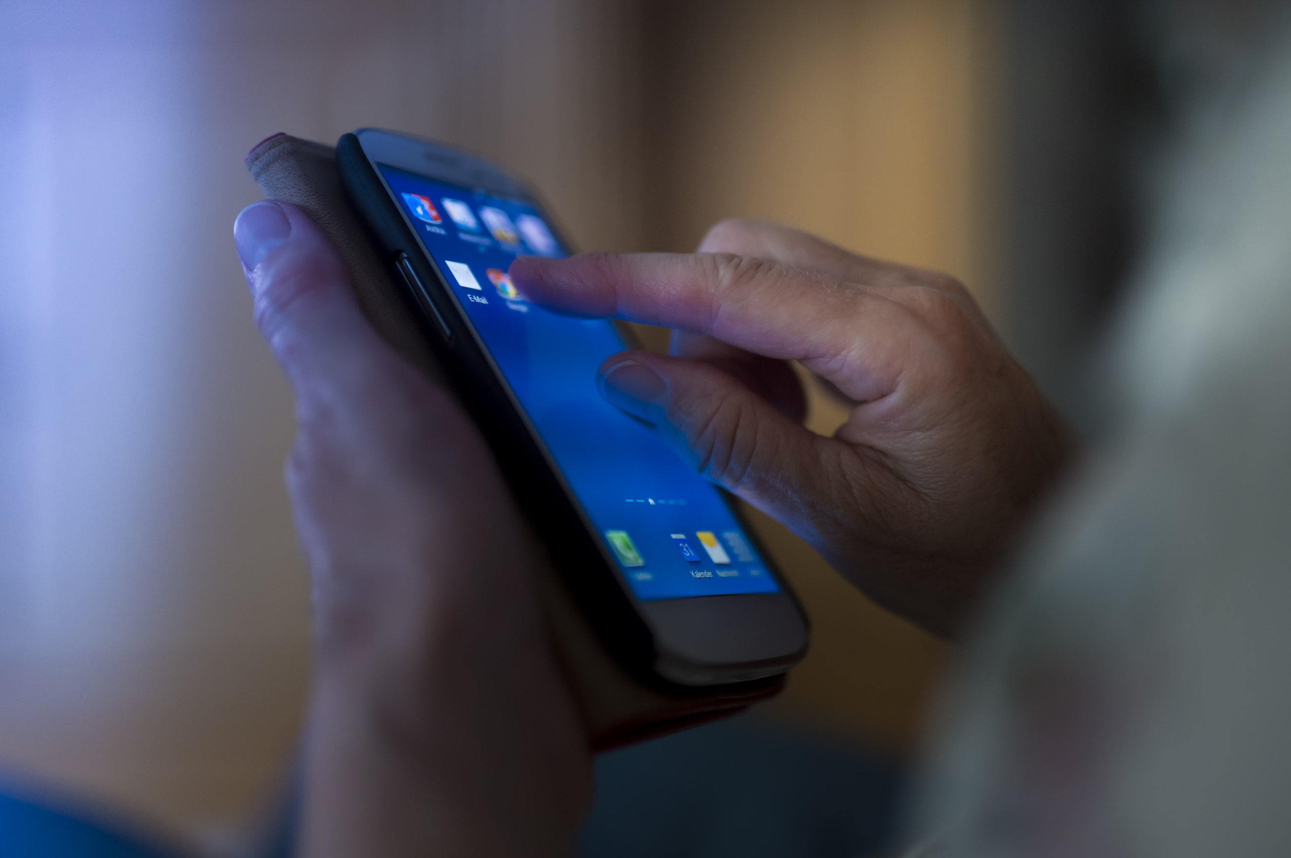 Hands of senior touching smartphone