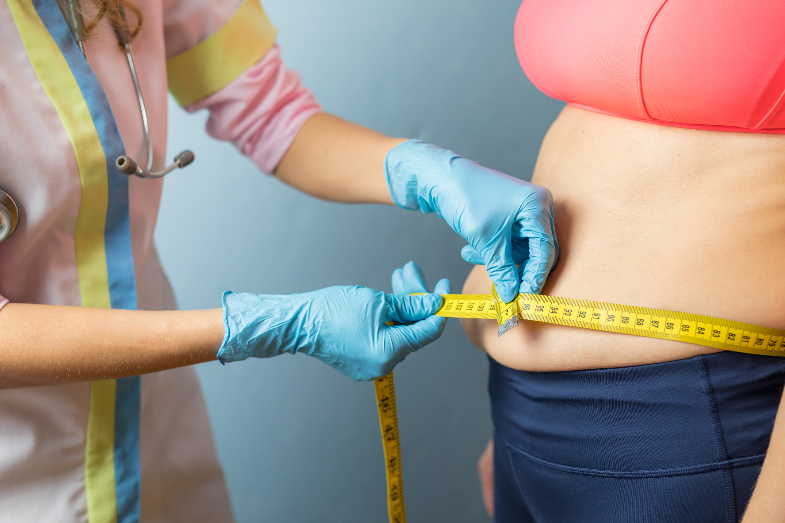 Doctor taking obese woman’s body fat measurements