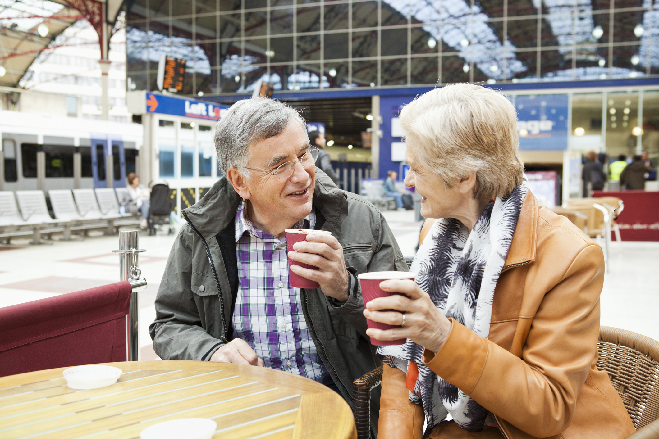 mature couple drinking coffee at railway station.