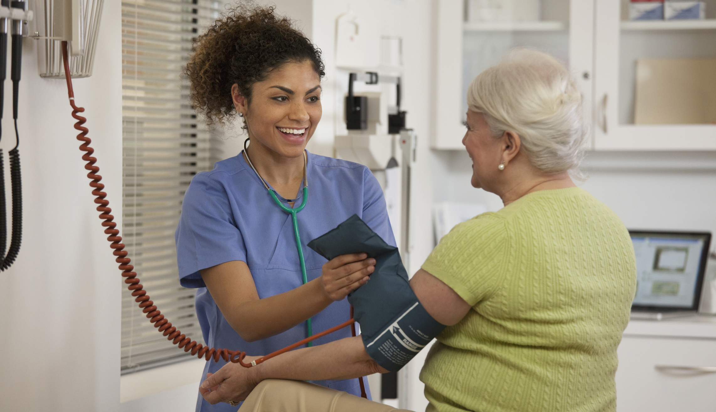 Nurse taking woman’s blood pressure