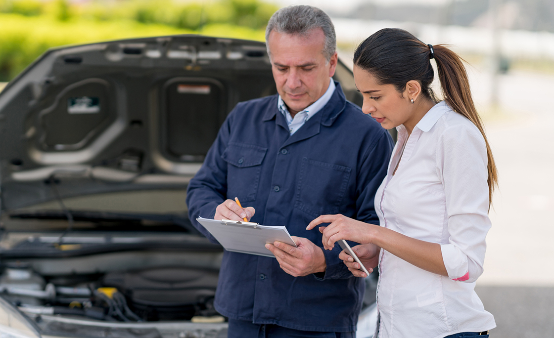 Woman talking to a mechanic about her car