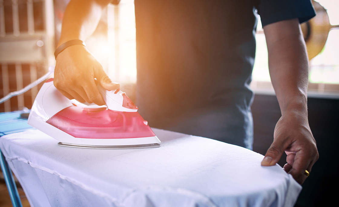 Midsection Of Man Ironing Shirt At Home