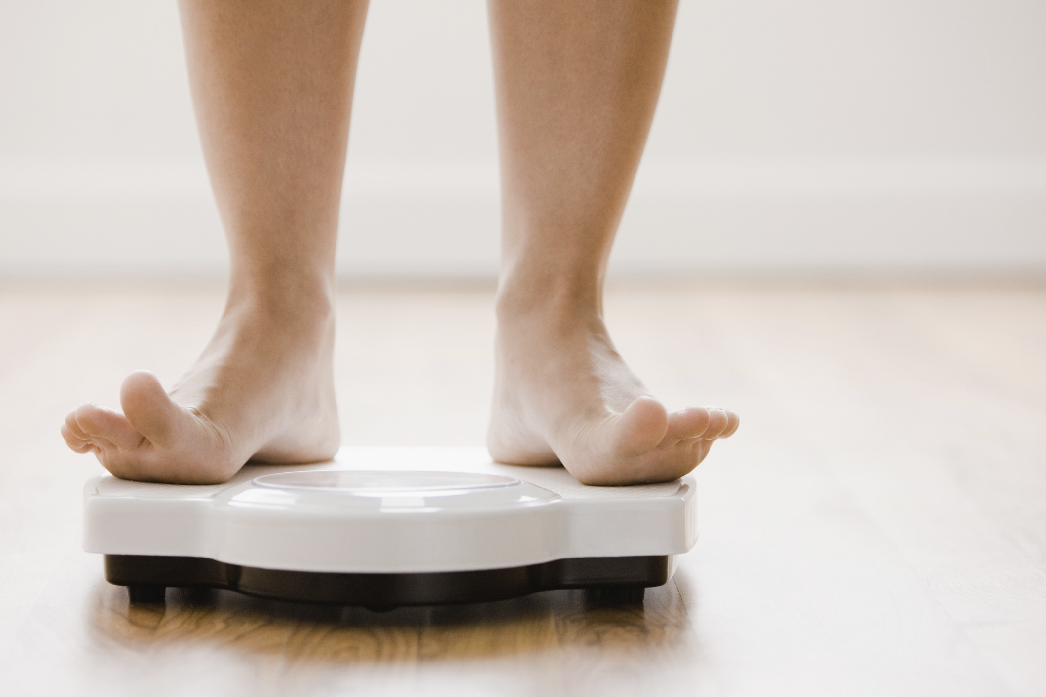 Caucasian woman’s feet standing on scale