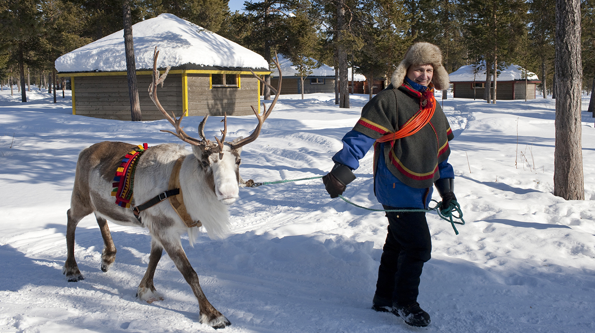 Saami man with a reindeer in Jukkasjarvi, Sweden