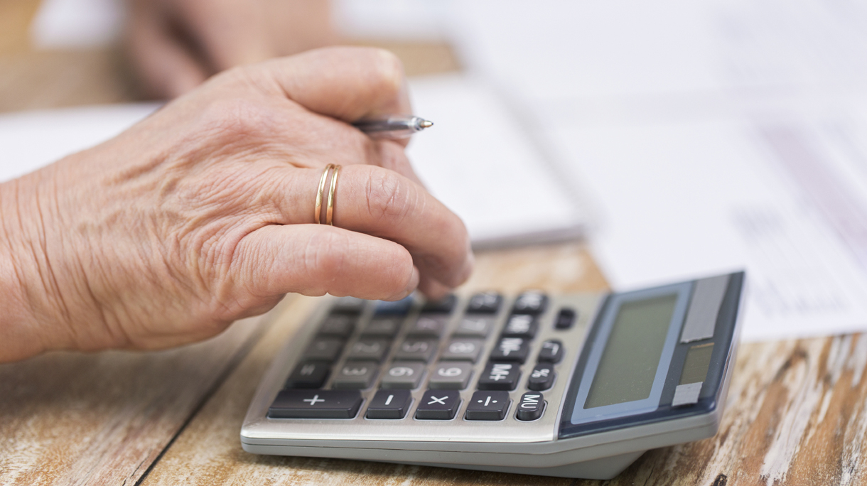 close up of senior woman counting with calculator