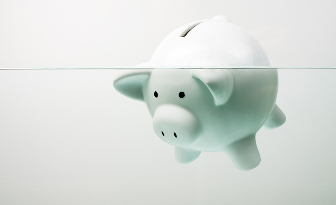 White piggy bank sinking in water