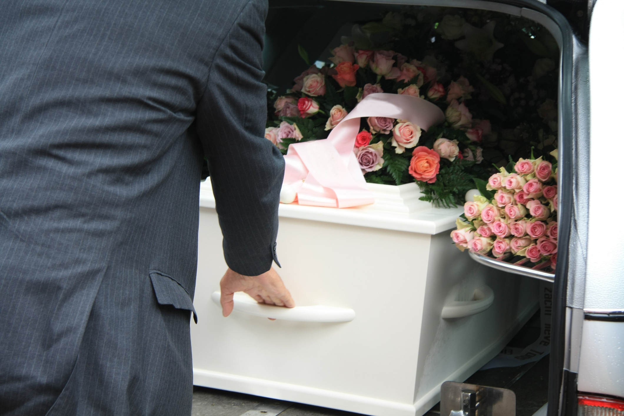White coffin in a grey hearse