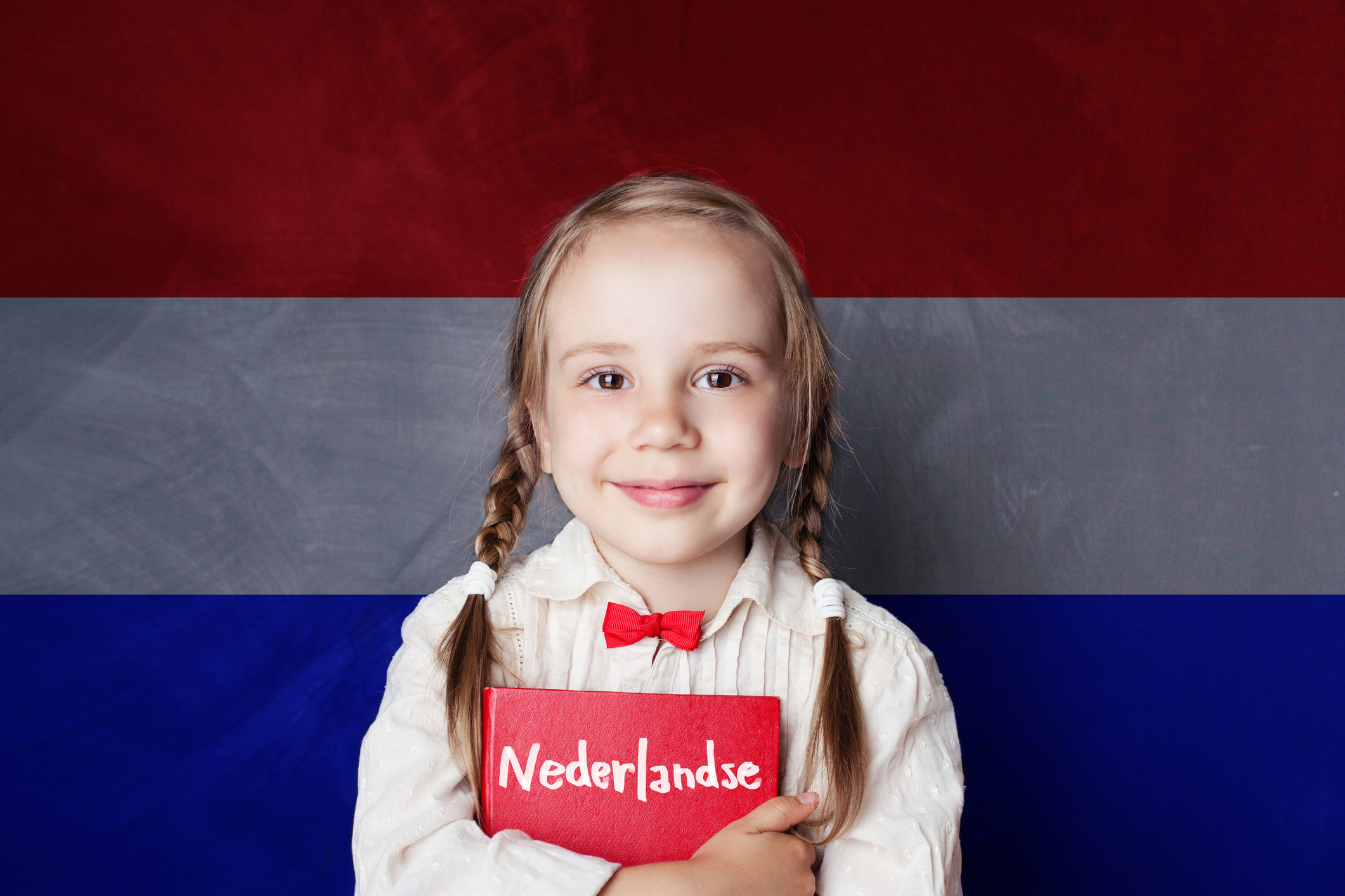 Beautiful child girl smiling and holding book in Netherlandish language school. Learning Dutch