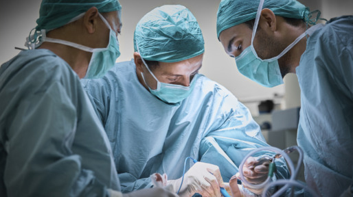 Surgeons operating patient for breast implant