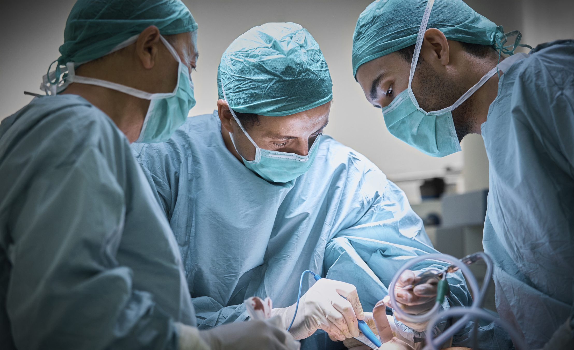 Surgeons operating patient for breast implant