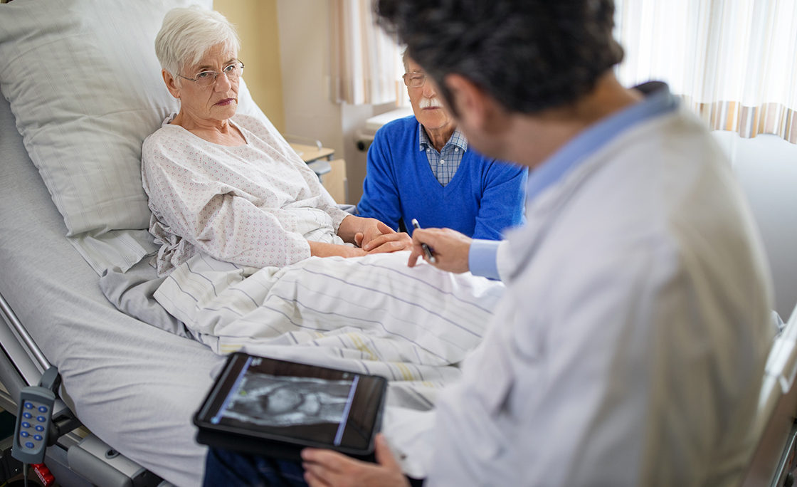 Doctor explaining the knee replacement treatment to senior patient