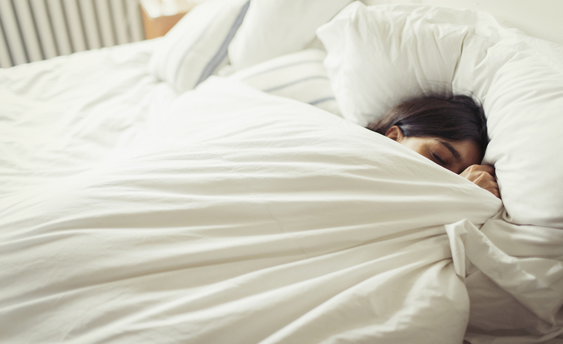 Tired young woman sleeping in bed