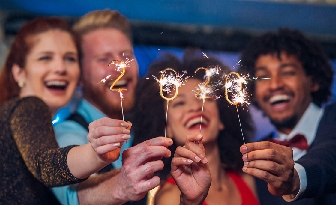 Smiling people holding sparklers