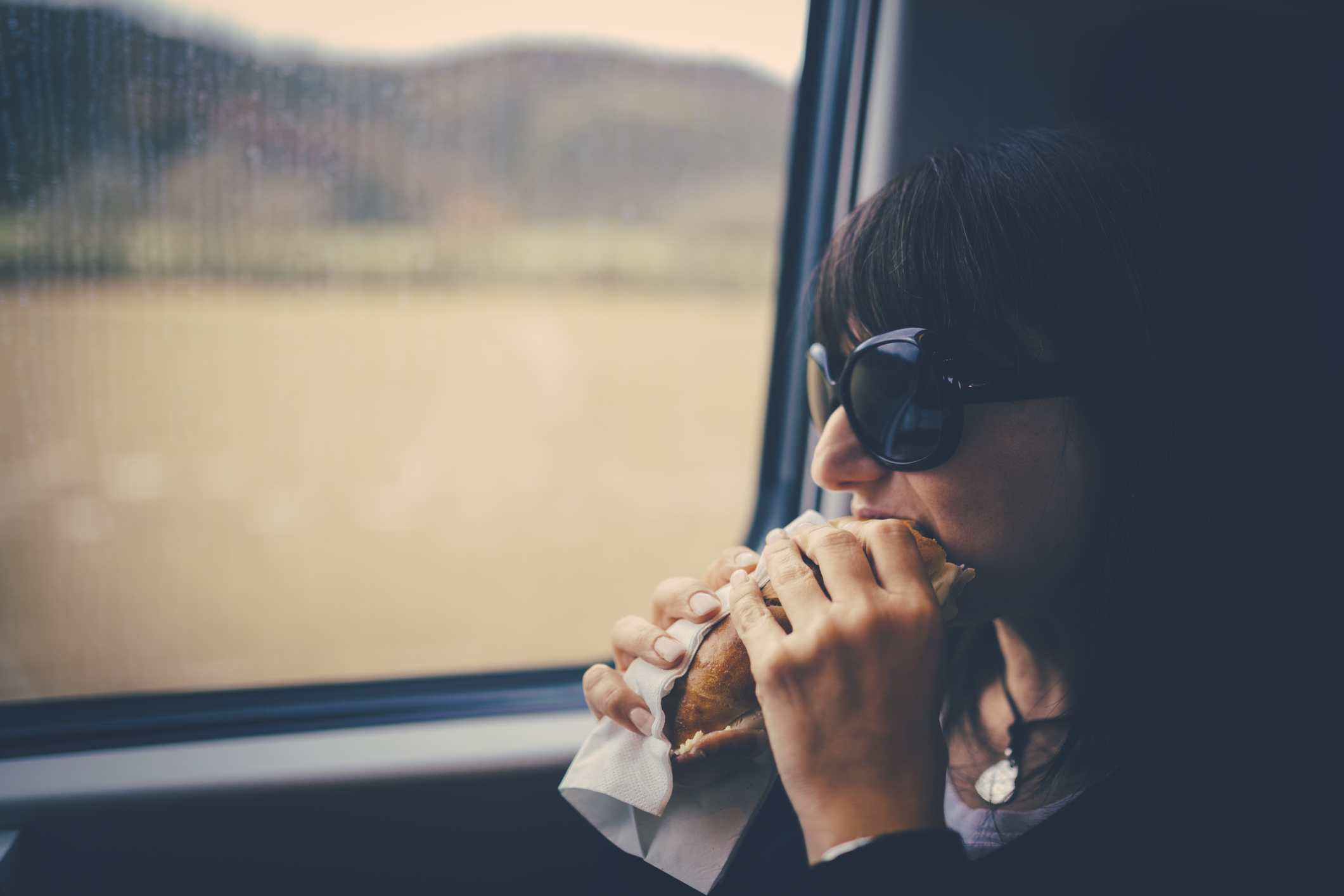 Woman on train eating a sandwich