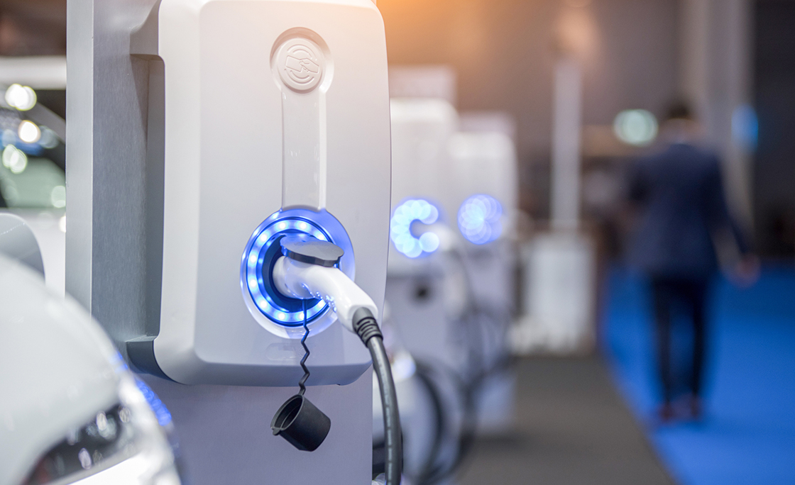 Power supply for electric car charging. Electric car charging station. Close up of the power supply plugged into an electric car being charged.