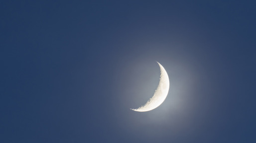 Crescent moon against clear sky at night.