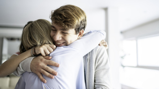 Teenager grandson embracing grandmother