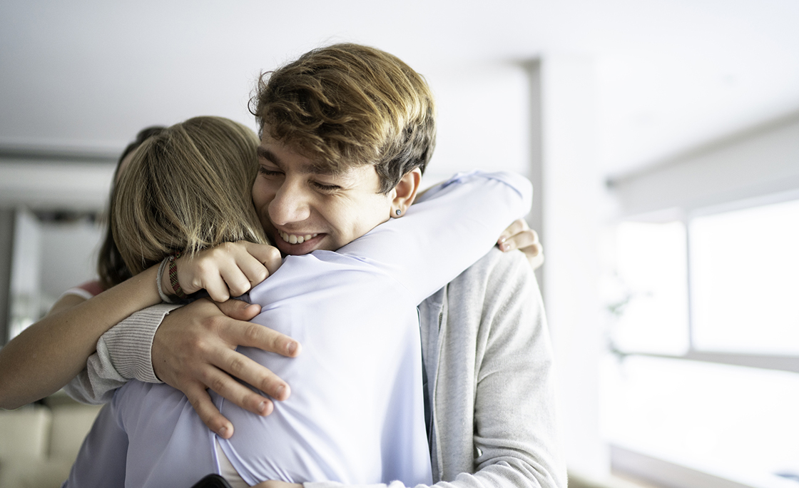 Teenager grandson embracing grandmother