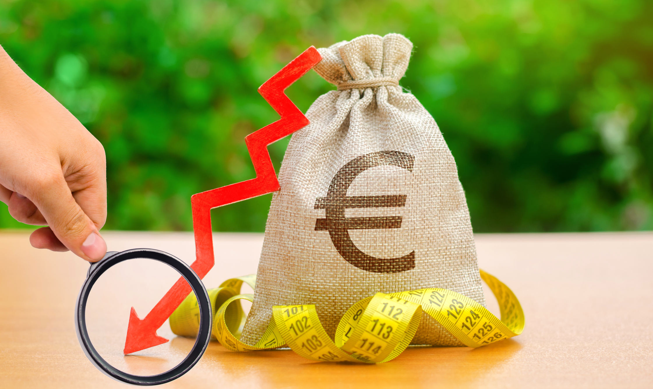 Bag with money and tape measure with arrow to down. Falling wages and welfare. Low profits and liquidity of investments. The concept of bankruptcy. Bad business payback. Capital outflow. Euro