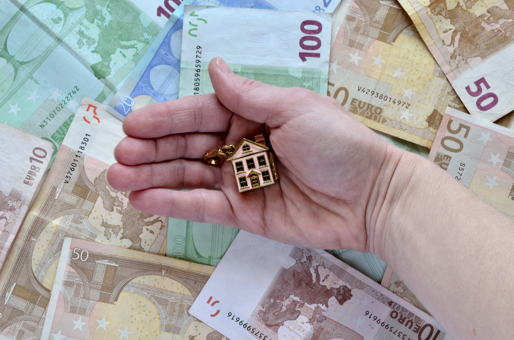 Money and a hand with a house